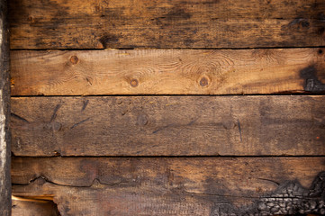 Black and brown burnt wall of house of wooden planks with embossed texture. background for copy space. concept of loss of real estate or home. property insurance