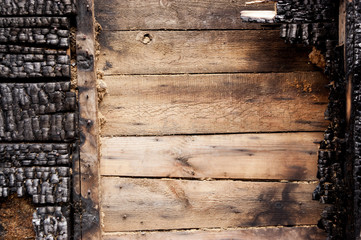 brown burnt wall of house of wooden planks with embossed texture. background for copy space. concept of loss of real estate or home. property insurance