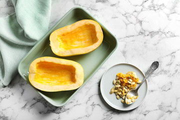 Flat lay composition with cut spaghetti squash and seeds on marble background
