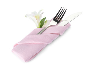 Folded napkin with fork, knife and flower on white background