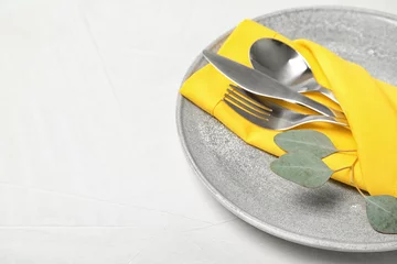 Tuinposter Plate with cutlery and napkin on light table, closeup. Space for text © New Africa