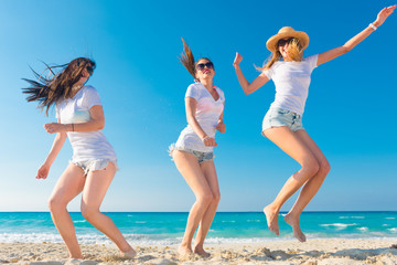 Cuatro amigos con camisetas blancas para anunciar una empresa en la playa.