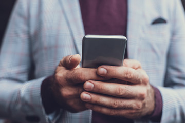 Close up of the male hands holding carefully modern convenient smartphone