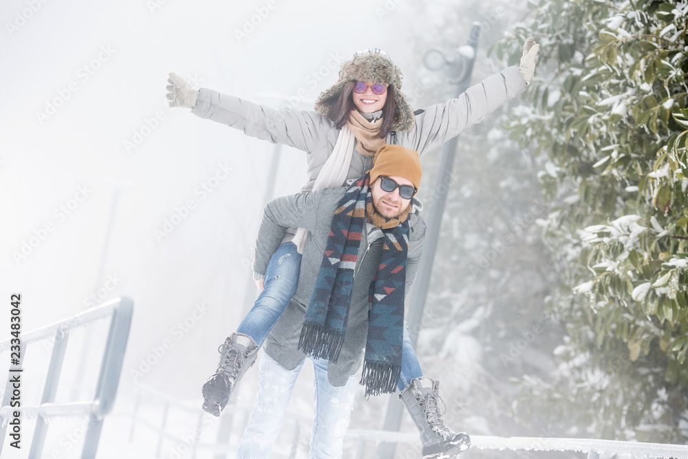 Wall mural young couple playing in snow in nature