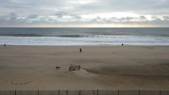 People are walking on the beach of Belmar.