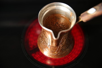 coffee is brewed in the Turk on the electric stove. Top view.
