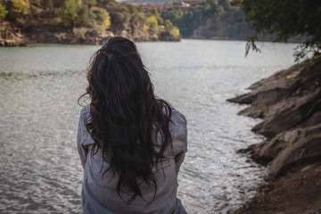 woman touching her hair in the river looking at the landscape