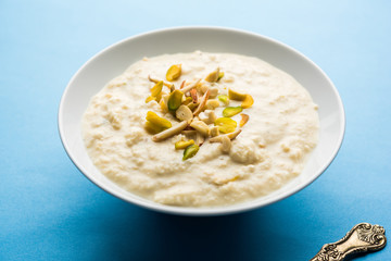 Sweet Rabdi or Lachha Rabri or basundi, made with pure milk garnished with dry fruits. Served in a bowl over moody background. Selective focus
