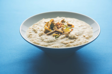 Sweet Rabdi or Lachha Rabri or basundi, made with pure milk garnished with dry fruits. Served in a bowl over moody background. Selective focus