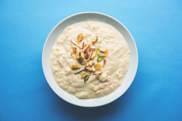 Sweet Rabdi or Lachha Rabri or basundi, made with pure milk garnished with dry fruits. Served in a bowl over moody background. Selective focus