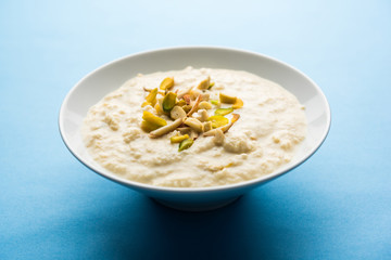 Sweet Rabdi or Lachha Rabri or basundi, made with pure milk garnished with dry fruits. Served in a bowl over moody background. Selective focus