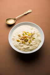 Sweet Rabdi or Lachha Rabri or basundi, made with pure milk garnished with dry fruits. Served in a bowl over moody background. Selective focus