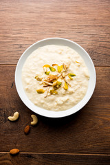 Sweet Rabdi or Lachha Rabri or basundi, made with pure milk garnished with dry fruits. Served in a bowl over moody background. Selective focus