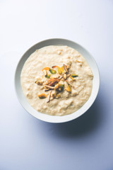 Sweet Rabdi or Lachha Rabri or basundi, made with pure milk garnished with dry fruits. Served in a bowl over moody background. Selective focus