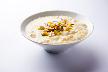 Sweet Rabdi or Lachha Rabri or basundi, made with pure milk garnished with dry fruits. Served in a bowl over moody background. Selective focus