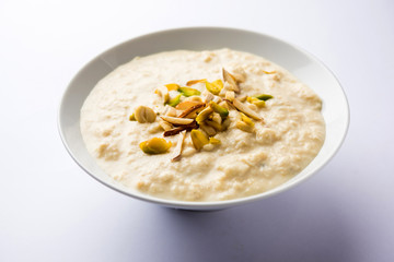 Sweet Rabdi or Lachha Rabri or basundi, made with pure milk garnished with dry fruits. Served in a bowl over moody background. Selective focus