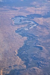 Aerial view of topographical Rocky Mountain landscapes on flight over Colorado and Utah during autumn. Grand sweeping views of rivers, mountain and landscape patterns. Top view, Rockies and Wasatch Fr