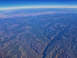 Aerial view of topographical Rocky Mountain landscapes on flight over Colorado and Utah during autumn. Grand sweeping views of rivers, mountain and landscape patterns. Top view, Rockies and Wasatch Fr