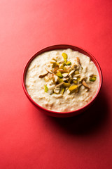 Sweet Rabdi or Lachha Rabri or basundi, made with pure milk garnished with dry fruits. Served in a bowl over moody background. Selective focus