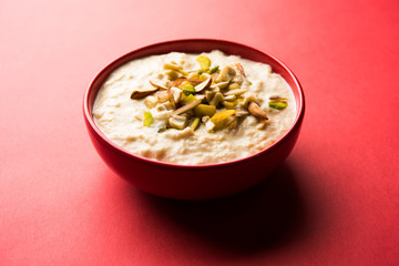 Sweet Rabdi or Lachha Rabri or basundi, made with pure milk garnished with dry fruits. Served in a bowl over moody background. Selective focus