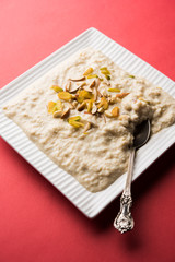 Sweet Rabdi or Lachha Rabri or basundi, made with pure milk garnished with dry fruits. Served in a bowl over moody background. Selective focus