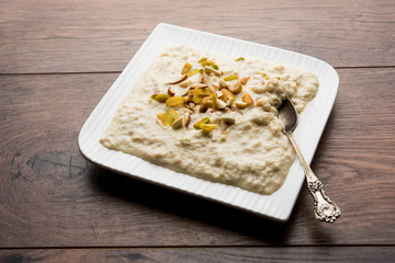 Sweet Rabdi or Lachha Rabri or basundi, made with pure milk garnished with dry fruits. Served in a bowl over moody background. Selective focus