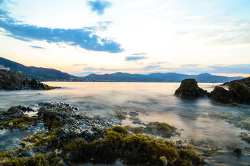 Fototapeta na wymiar Sunset at costa brava with rocks in moving water