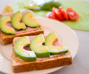 Avocado sandwich with Whole wheat bread, ham and tomatoes Is a healthy diet