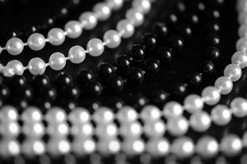 Necklace of black and white beads on a dark background close up. Black and white