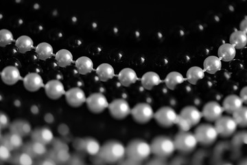Necklace of black and white beads on a dark background close up. Black and white