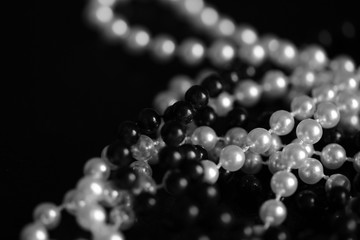 Necklace of black and white beads on a dark background close up. Black and white