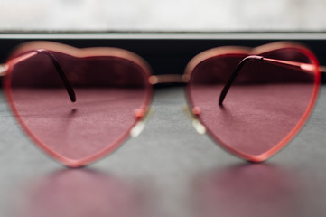 Pink heart-shaped glasses closeup. Happiness concept