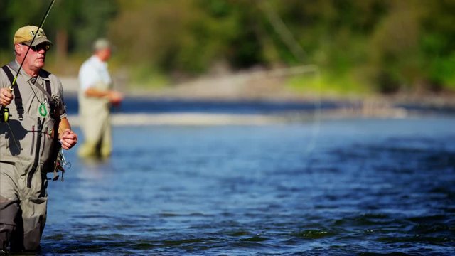American fisherman wading in Wilderness river fly fishing USA