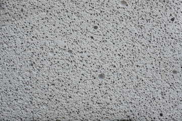 Close-up porous pattern of white concrete surface.