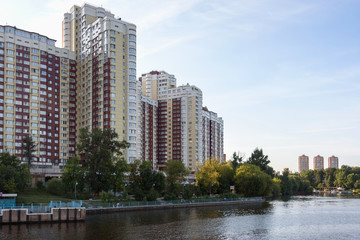 Fototapeta na wymiar Russia, Moscow August 2018: Building of a modern residential complex on the river bank. View from the boat.