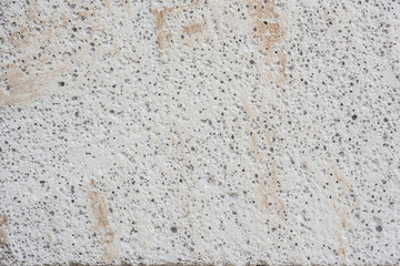 Close-up porous pattern of white concrete surface.