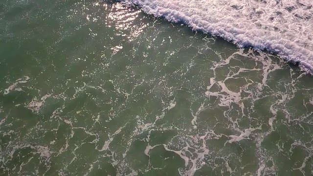 Aerial footage of waves rolling into shore in turquoise waters off the coast of Southern California. Great for backgrounds, abstracts, and transitions.  Shot in high speed photography.