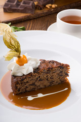 Slice of chocolate cake served with cupt tea and mint
