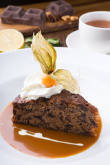 Slice of chocolate cake served with cupt tea and mint
