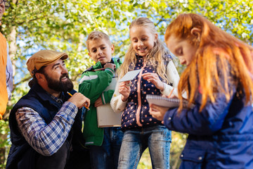 So interesting. Positive smart children smiling while enjoying an outdoor lesson