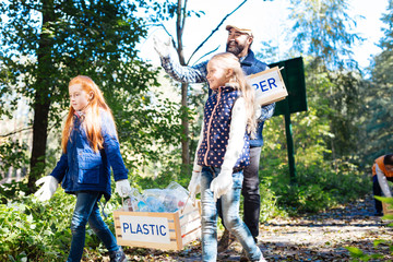 Volunteer project. Cute young girls taking away plastic garbage while volunteering for an ecological project