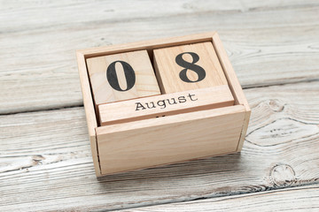 wooden cube shape calendar for AUG 8 on wooden background