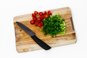 Geschnittenes Gemüse und Küchenmesser auf einem Holzbrett