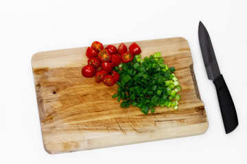 Geschnittenes Gemüse und Küchenmesser auf einem Holzbrett