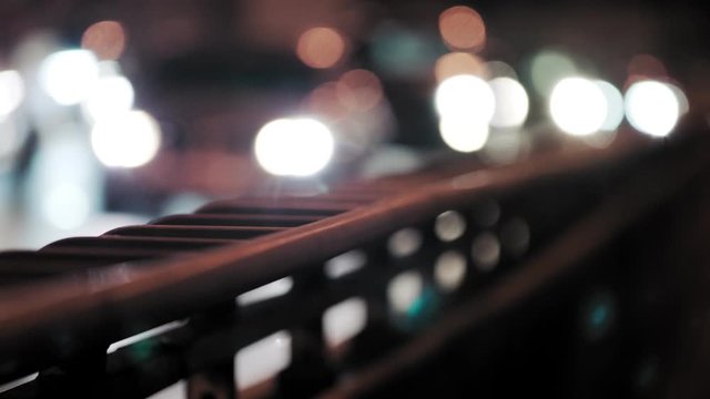 Bokeh of Cars Driving on Highway at Night, Grungy handrail in foreground