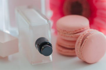 Beautiful pink perfume bottles with flower and macaroons.  Luxury blurred perfumery background.