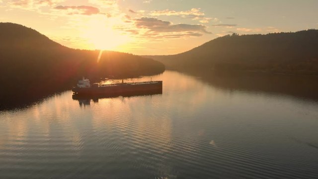 An aerial view of a oil tanker sitting in Burrard Inlet near Deep Cove in Vancouver, BC, at sunrise.