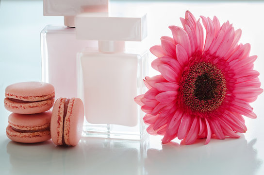 Beautiful pink perfume bottles with flower and macaroons.  Luxury perfumery background