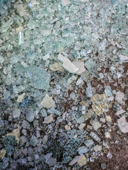 Broken glass pieces on an asphalt surface