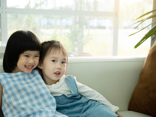  two child  smile on a sofa with copy space.